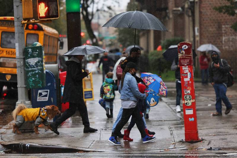 美东沿海地区今（27）日遭飓风等级的东北大风（nor’easter）袭击。图为美国纽约民众在过马路时撑着雨伞过马路。（法新社）(photo:LTN)