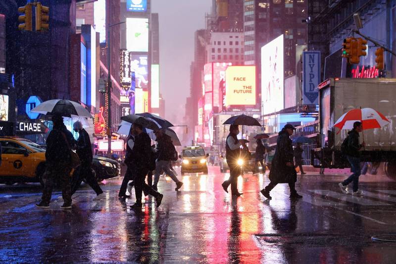 美东沿海地区今（27）日遭飓风等级的东北大风（nor’easter）袭击。图为美国纽约民众在过马路时撑着雨伞过马路。（路透）(photo:LTN)
