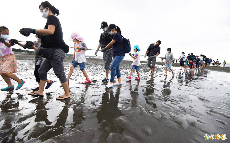 健行科技大學國際參訪團體驗在地海洋牽罟文化齊力從岸邊拉起繩索，感受前人海邊捕魚的樂趣。（記者李容萍攝）