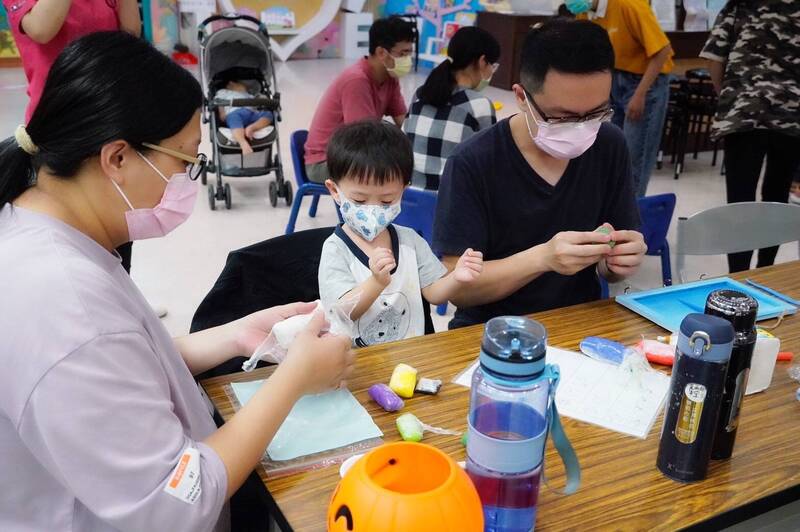 萬聖節爸爸媽媽陪孩子捏黏土。（民政局提供）