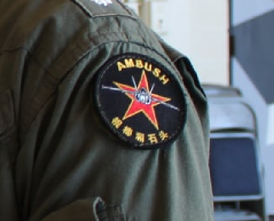 军官臂章上也有类似中国解放军红星军徽，并以英文写着「AMBUSH（伏击）」，除此之外，臂章下方还有5个简体字，写着「棍棒和石头」。（图取自VFC-12 FACEBOOK）(photo:LTN)