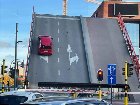 比利时鲁汶移动式桥樑玛丽图马斯桥日前上升时，墙面上还有一辆红色小客车，当场滑落坠地翻车。（图翻摄自推特）(photo:LTN)