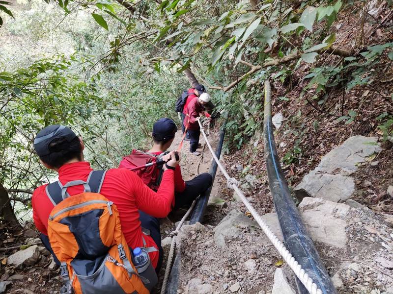 台中市消防局搜救人員協助蔡姓兄弟往山下撤退。（記者歐素美翻攝）