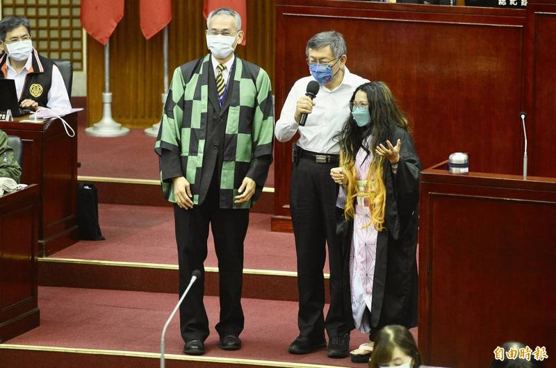 台北市議員郭昭巖（右）今日在議會質詢時，扮成「鬼滅之刃彌豆子」的造型，希望市長柯文哲（右二）能儘力推廣台北熊好券。（記者叢昌瑾攝）