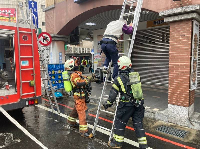 消防員出動樓梯協助民眾脫困。（桃園市政府消防局第三大隊蘆竹分隊提供）