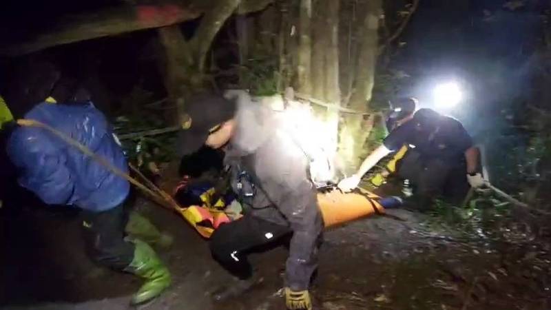 救難人員合力將死者遺體運送至栗松溫泉入口。（記者陳賢義翻攝）