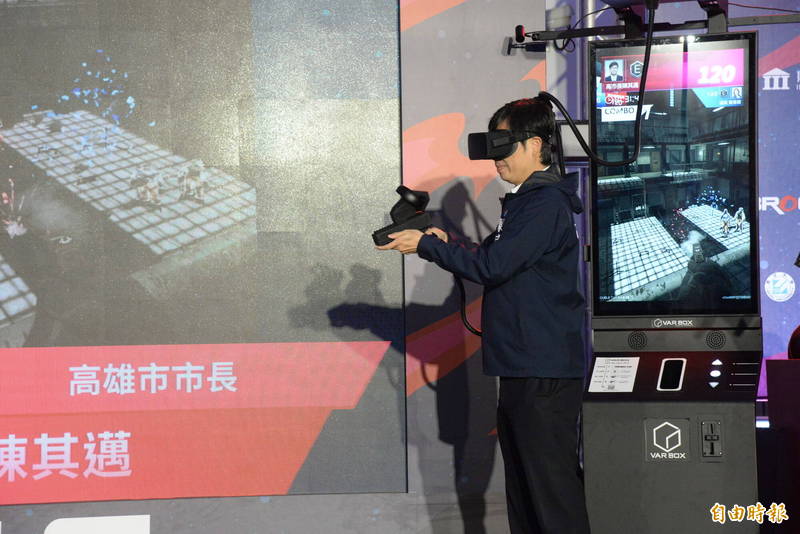 高雄市長陳其邁戴上VR體驗搶靶競技遊戲。（記者許麗娟攝）