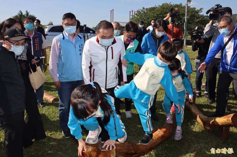 樹林「山佳荷花池」周遭設有漂流木休閒設施，市長侯友宜陪小朋友玩平衡木。（記者翁聿煌攝）