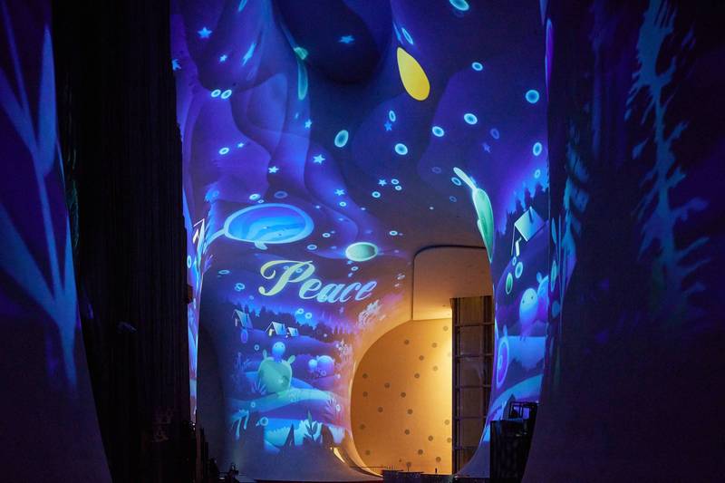 台中國家歌劇院推出耶誕影像《光的四重奏》，將大劇院前廳19米高曲牆幻化為西班牙聖家堂光影彩繪，也充滿軟萌奇幻生物居住的魔法世界。（台中國家歌劇院）