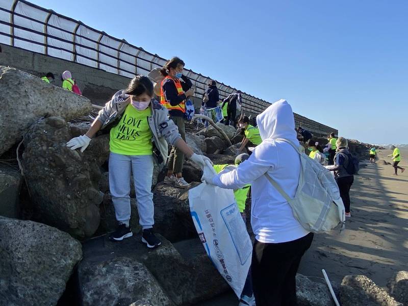 新竹縣愛鄰協會與綠光教室課輔學生百人今天到南寮海邊淨灘，清出253公斤海邊廢棄物。（照片由協會提供）