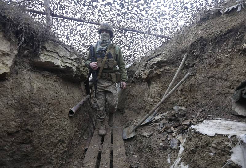 俄羅斯與烏克蘭情勢升至近年來最高點，圖為烏國士兵全副武裝在戰壕中行走的畫面。（美聯社）