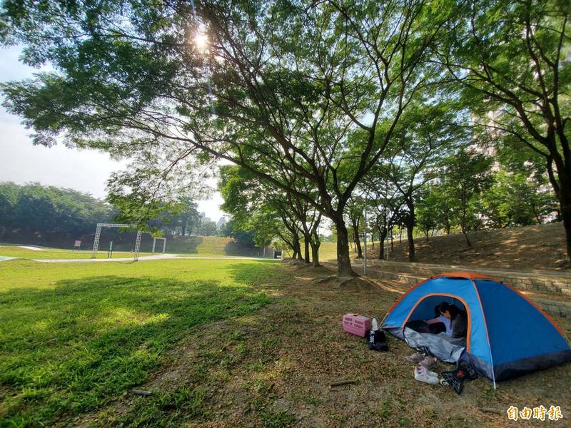 寶業里滯洪池營造綠蔭、草地，吸引親子搭帳棚野餐遊憩。（記者陳文嬋攝）