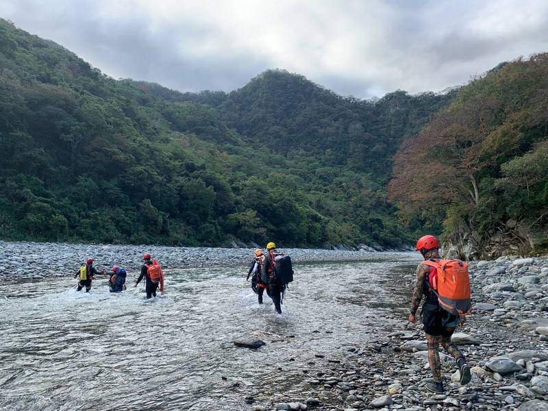 搜救隊員溯溪找尋2名被溪水沖失的登山客。（記者陳賢義翻攝）