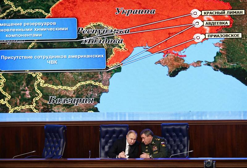 俄罗斯总统普廷（左）与俄罗斯武装部队参谋总长吉拉西莫夫（Valery Gerasimov）21日在国防部扩大会议上交谈，上方显示俄方指称美国民间军事服务公司在乌克兰东部的部署状况。（美联社）(photo:LTN)
