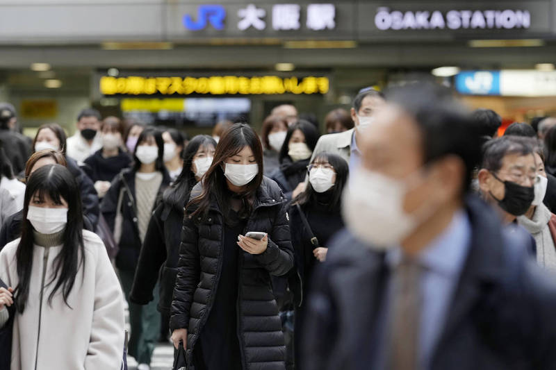 日本京都府、大阪府今天各新增1例感染源不明的Omicron本土病例。圖為大阪民眾戴口罩防疫。（美聯社）