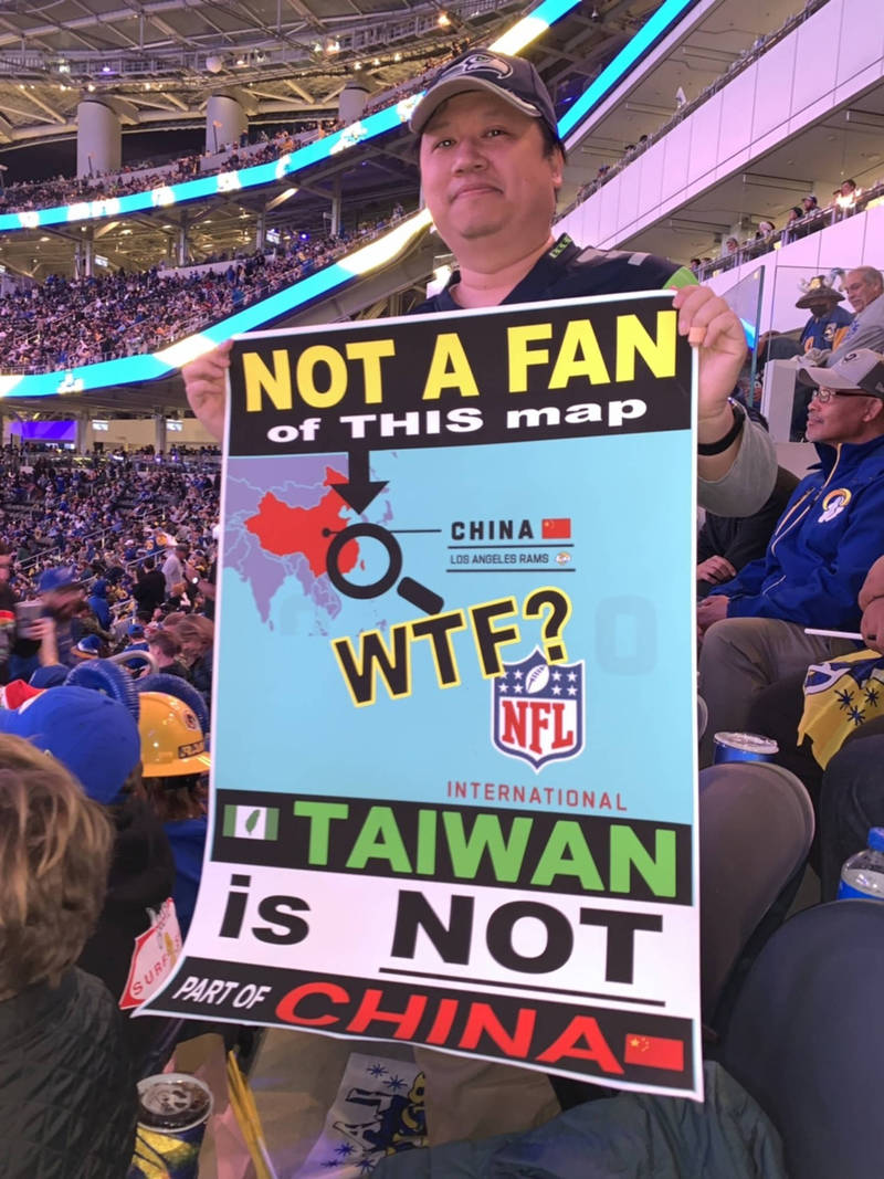 灣僑民吳兆峯（圖）21日帶著標語到職業美式足球聯盟（NFL）洛杉磯公羊隊（Los Angeles Rams）主場抗議NFL地圖把台灣跟中國用同一個顏色標示。（中央社）