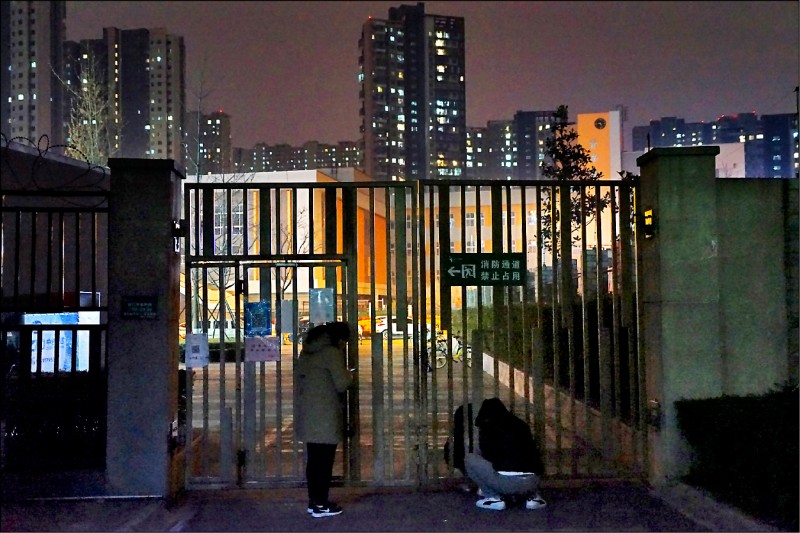 人口1300萬的中國西安市23日起全城封鎖，一名市民當天晚上站在一處封閉的社區內。（歐新社）