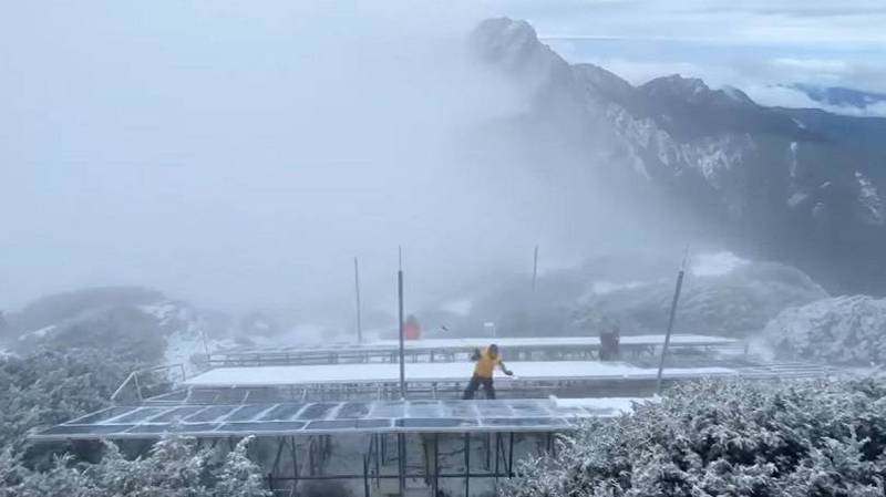 玉山今有2波降雪，積雪約2公分。中央氣象局長鄭明典也在臉書分享，玉山氣象站正賣力剷除太陽能板積雪的人員。（圖擷取自鄭明典臉書）