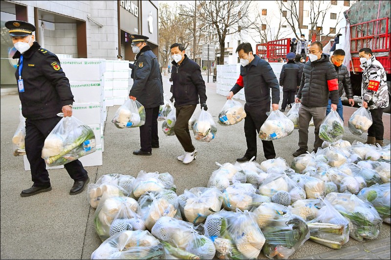 中国官媒新华社29日发布照片，西安各区官员拿着一袋袋民生物资准备发送给因防疫被禁止出门的居民。（美联社）(photo:LTN)