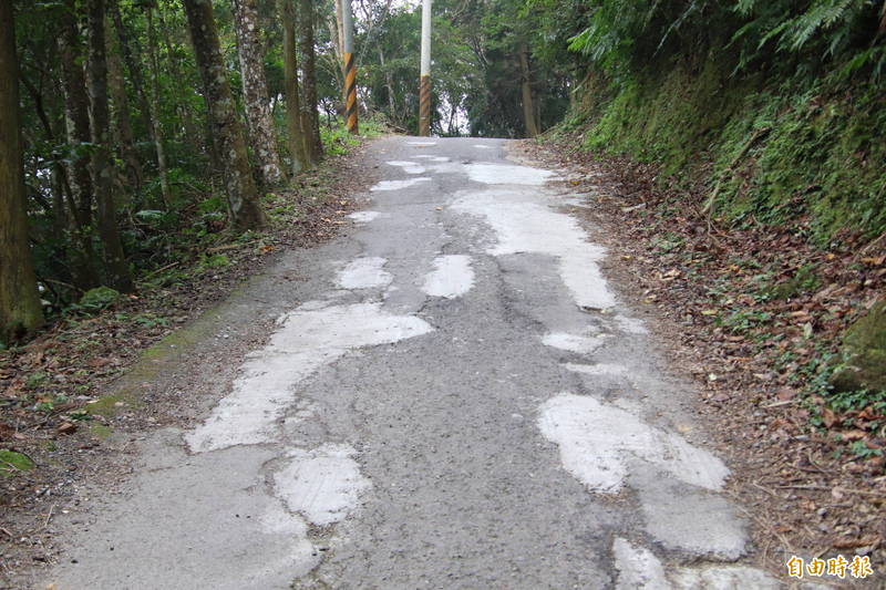 新竹縣橫山鄉豐鄉村通往大旗崠山頂的產業道路破損嚴重，鄉長張志弘說，有鄉親自力救濟拿水泥自己整治路面。（記者黃美珠攝）