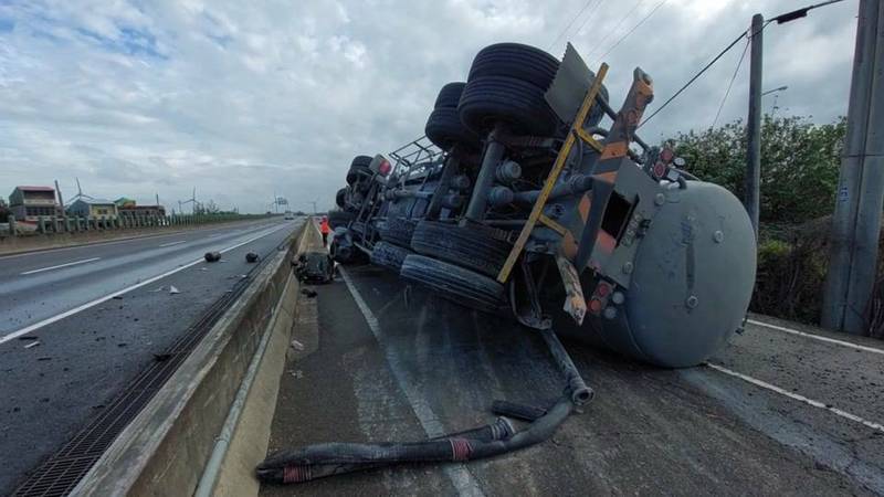 槽車失控擦撞快車道護欄，整輛車翻覆在側車道上。（圖由民眾提供）