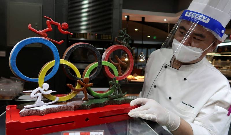 2022北京冬奧將於下月4日開幕。圖為北京廚師展示他烘焙的奧運五環標誌。（路透）