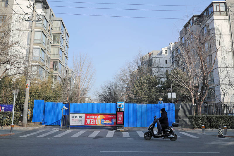 A scooter rides past an entrance to a residential neighbourhood that has been blocked off due to a COVID-19 outbreak, in Beijing yesterday.
Photo: EPA/EFE