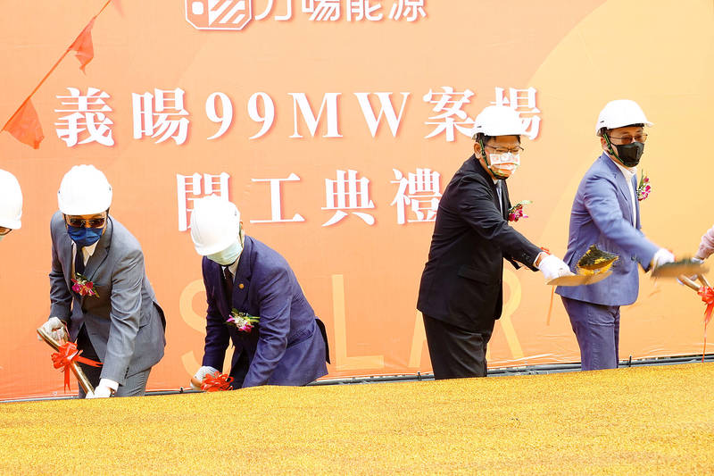 Pingtung County Commissioner Pan Men-an, second right, shovels dirt during a groundbreaking ceremony for a new solar farm in the county yesterday.
Photo: CNA