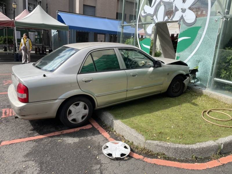 老翁汽車衝上草坪，再撞上急診室旁玻璃牆。（記者張瑞楨翻攝）