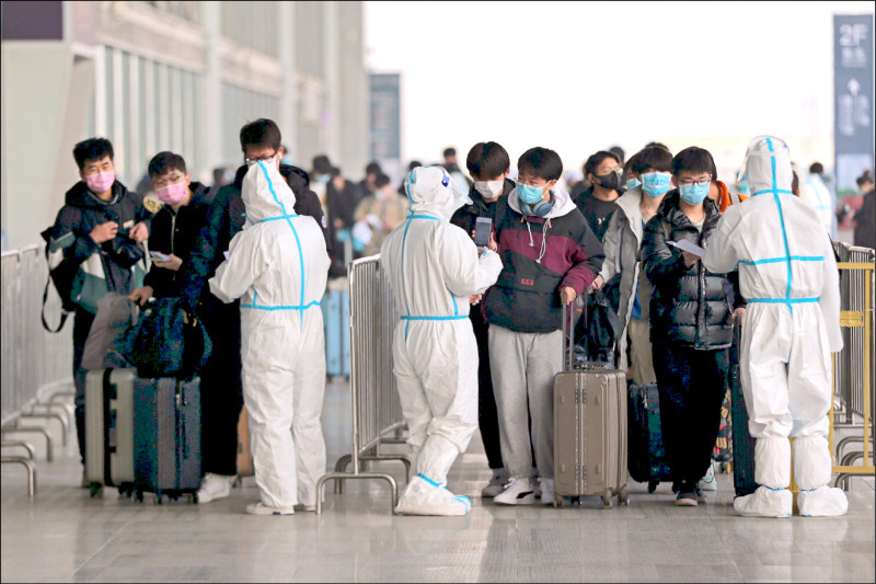 歷時四十天的中國鐵路春節運輸十七日起跑，運輸人口預計超過十一億人次，號稱「人類地表最大規模移動」。圖為十七日在陝西省省會西安市北車站，身穿防護衣的驗票人員查核學生乘客的健康碼。（路透）
