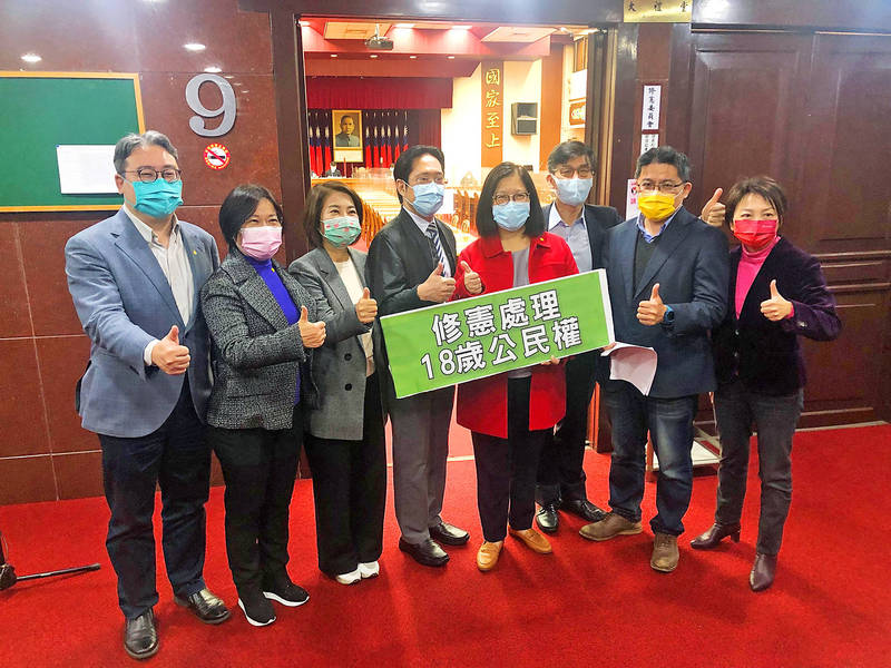 Legislators from the Democratic Progressive Party, Taiwan People’s Party and New Power Party give the thumbs-up at the Legislative Yuan in Taipei yesterday after the Constitutional Amendment Committee approved an amendment to the Constitution to lower the voting age to 18.
Photo: CNA