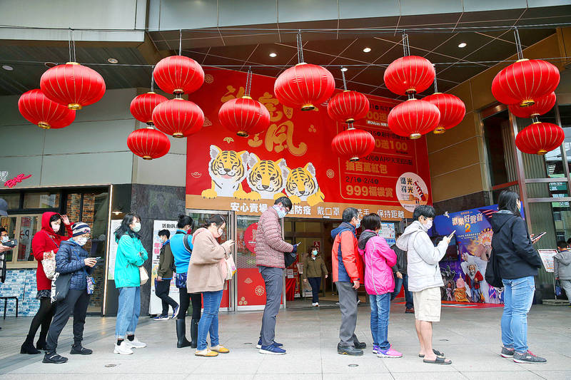 People line up outside the Global Mall in New Taipei City’s Jhonghe District for COVID-19 vaccination yesterday.
Photo: CNA