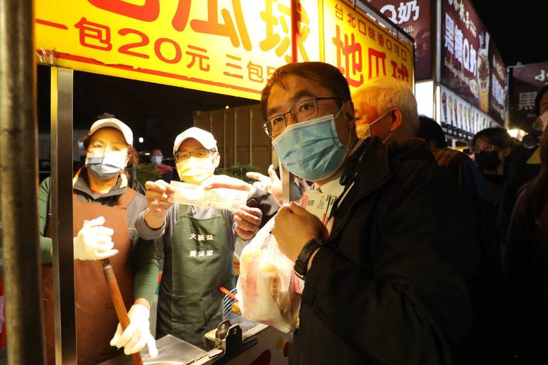 台南市長黃偉哲今晚到花園夜市實地示範使用夜市券，買了木瓜牛奶、炸魷魚、地瓜球。（台南市府提供）