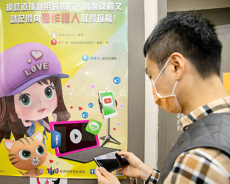 A man uses his cellphone in front of a poster promoting copyright law yesterday.
Photo: CNA