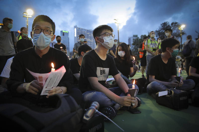 前香港眾志秘書長黃之鋒因2020年6月4日在維園參與燭光集會，遭起訴未經批准集結罪，判刑10月。圖為當時畫面。（美聯社）