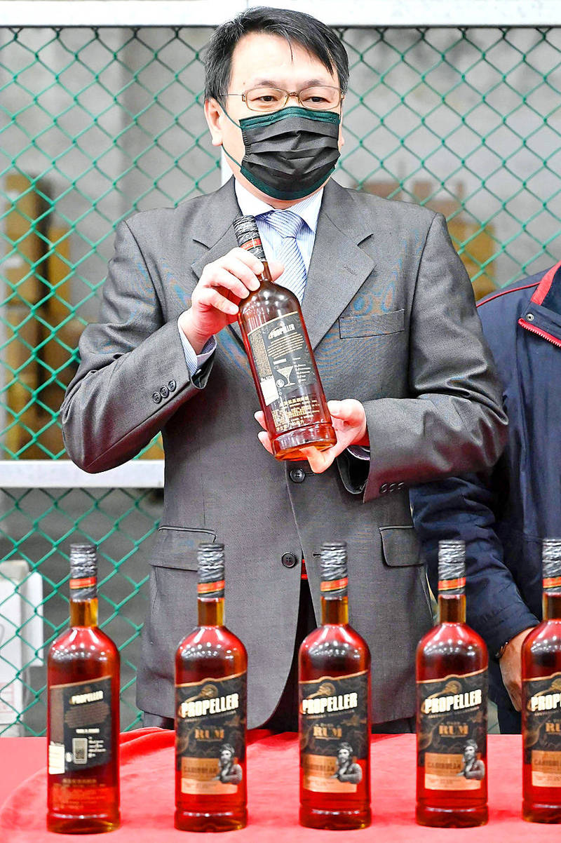 Taiwan Tobacco and Liquor Corp chairman Ting Yen-che yesterday in Taoyuan poses with bottles of rum imported from Lithuania.
<i>Warning: Excessive consumption of alcoholcan damage your health</i>
Photo: Sam Yeh, AFP