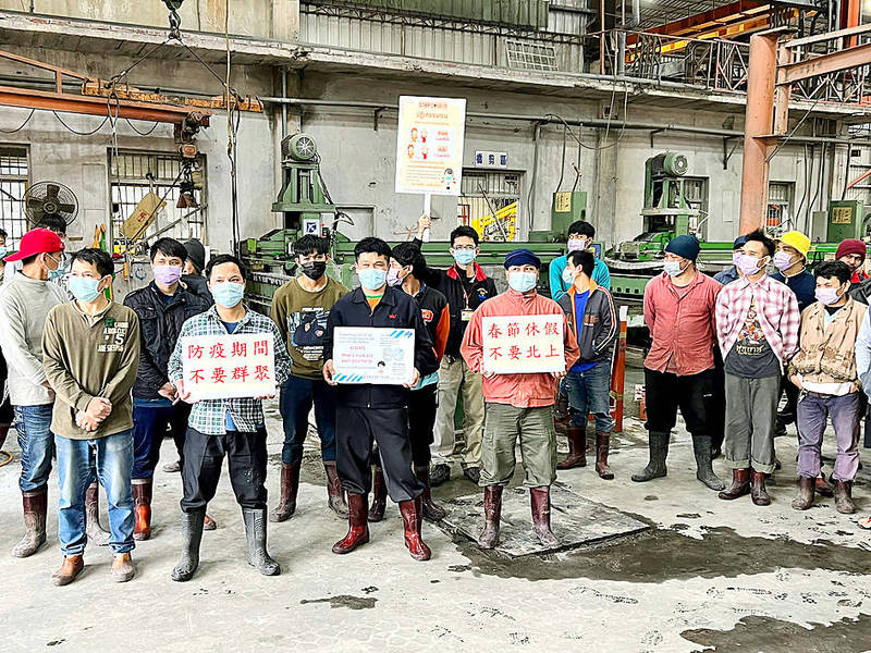 
Migrant workers hold up a sign and placards urging people to follow disease prevention guidelines in an undated photograph at a factory in Hualien County.
Photo courtesy of the Hualien County Government via CNA