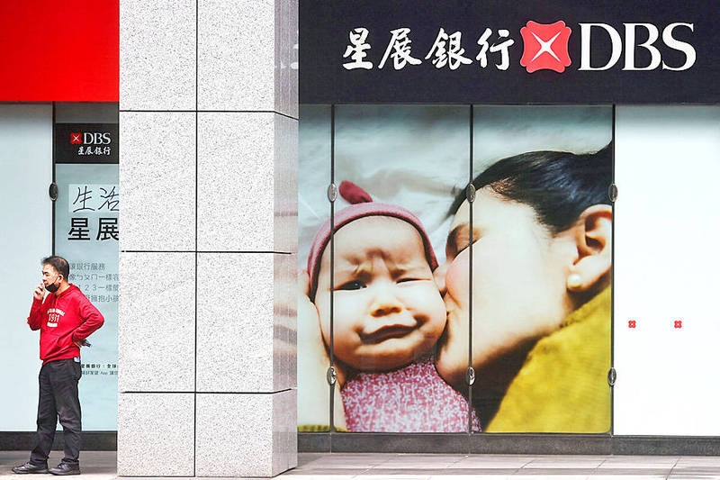 A man smokes a cigarette outside a DBS Bank Taiwan branch in Taipei yesterday.
Warning: Smoking can damage your health
Photo: Ann Wang/ Reuters