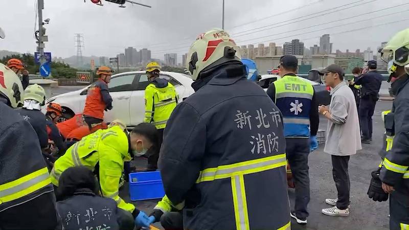 警方正積極搶救壓在車底的許婦。（記者徐聖倫翻攝）