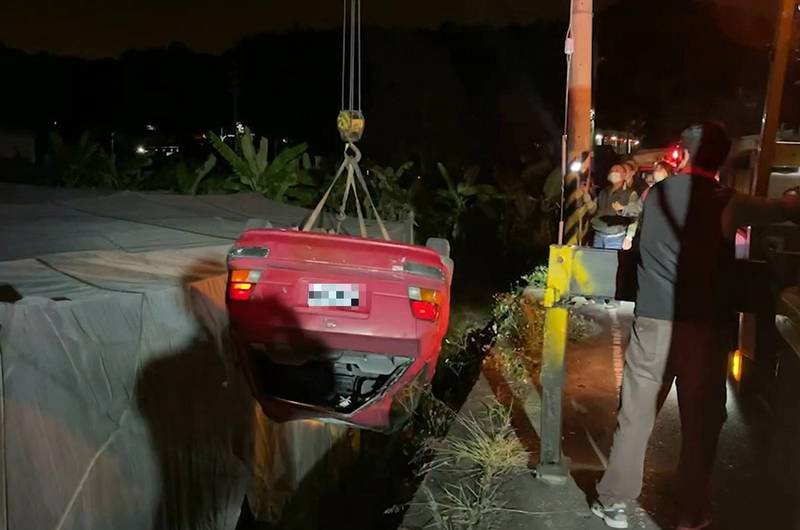 開車婦人行經彎道仍筆直向前開，連人帶車翻落道路，四輪朝天。（民眾提供）