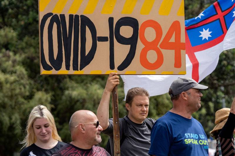 纽西兰8日起爆发反防疫禁令示威活动，上百民众佔领国会外街道，警民之间连日进行「创意」攻防，政府今（13）日起无限重复播放美国歌手巴瑞‧曼尼洛（Barry Manilow）及英国歌手詹姆仕‧布朗特（James Blunt）的洗脑金曲，希望能够借此驱离示威者。图为现场示威者手举「COVID-1984」标语，指反乌托邦小说《1984》。（路透）(photo:LTN)
