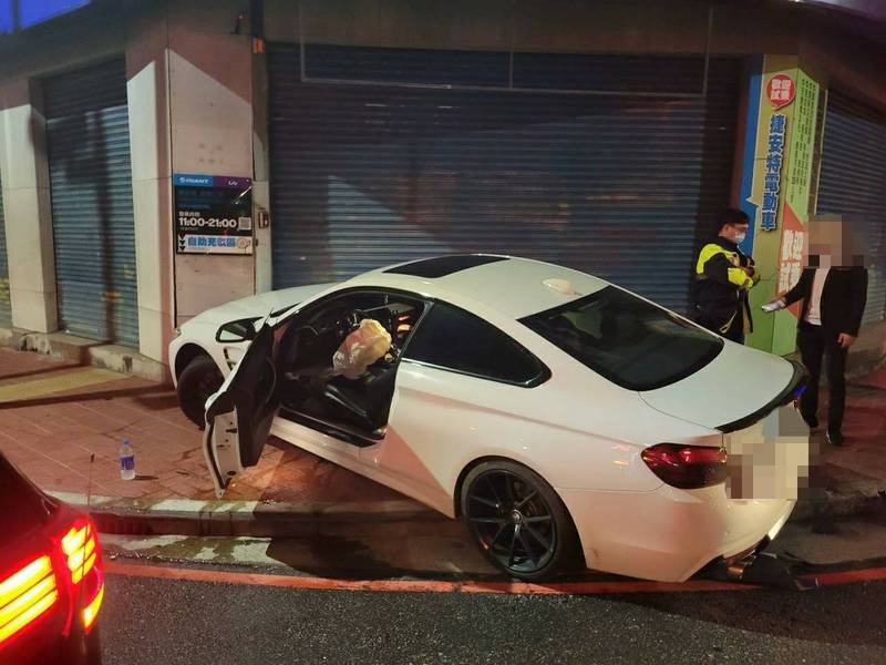 陳姓男子（右）酒後駕駛白色BMW失控打滑撞擊店家鐵門。（警方提供）