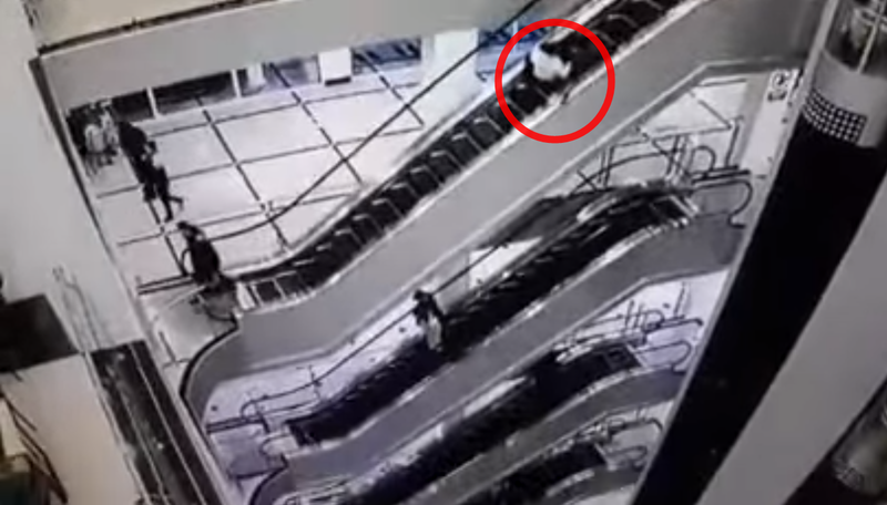 烏茲別克53歲爺爺抱著3歲孫女搭乘手扶梯，途中意外摔下。（翻攝Youtube）