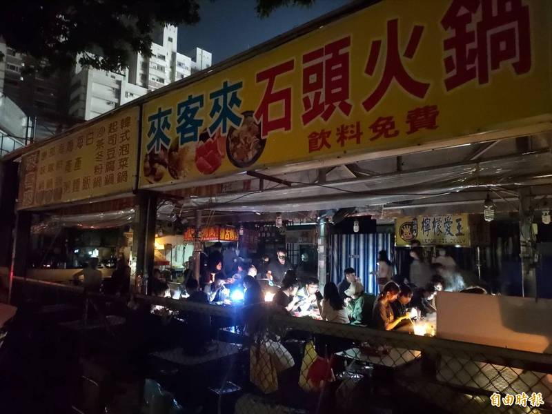 瑞豐夜市商家沒電照營業，顧客自備手機照光享用美食。（記者王榮祥攝）