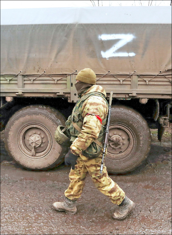 烏克蘭東部親俄勢力控制的頓內茨克地區，一名武裝人員五日行經一輛有Z字標示的軍用卡車。（路透）