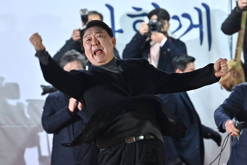 南韓總統大選國民力量黨候選人尹錫悅8日在選前最後造勢拿出招牌動作振臂高呼。（法新社）