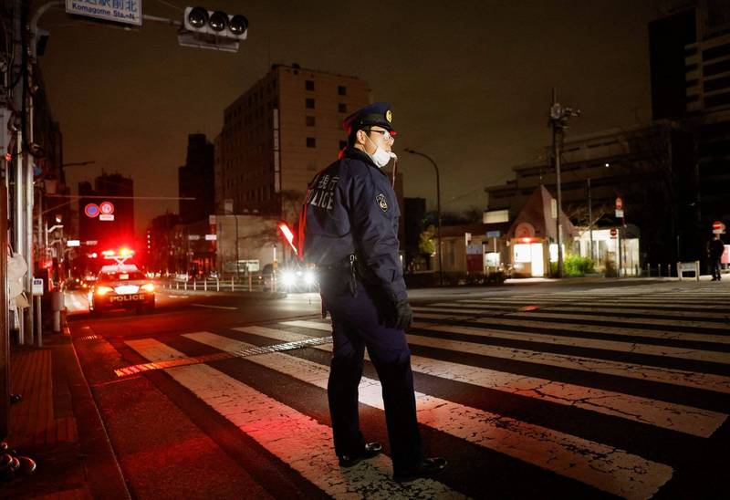 日本16日深夜发生7.3地震，东京等地大范围停电，一名警察站在街头维持秩序。（路透）(photo:LTN)