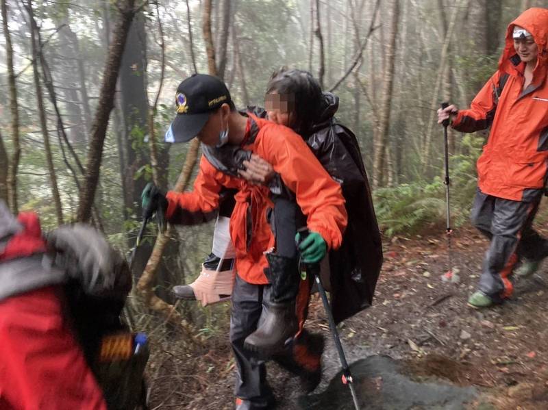 消防人員輪流揹著林婦下山。（民眾提供）