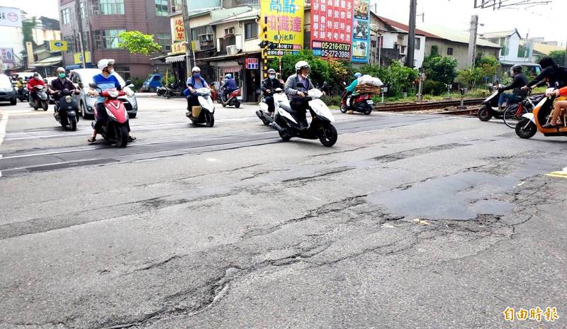 台鐵民雄鄉東榮平交道路面龜裂嚴重。（記者林宜樟攝）