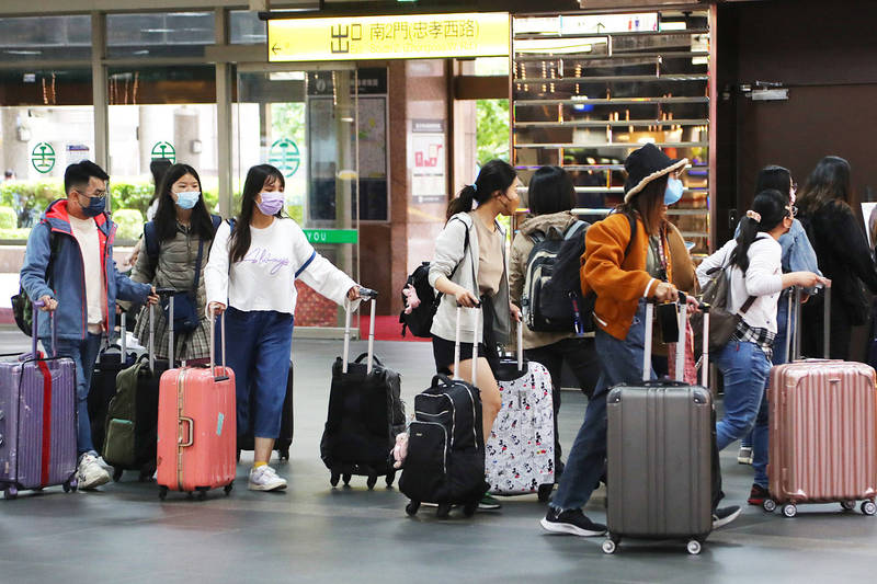 Passengers line up with their luggage at Taipei Railway Station yesterday.
Photo: CNA